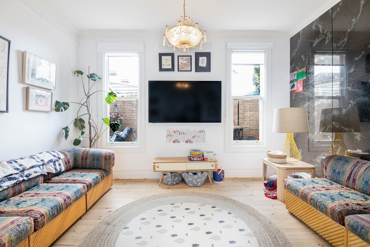 service-02 Spacious living room in Melbourne with contemporary design, featuring colorful sofas and elegant lighting.